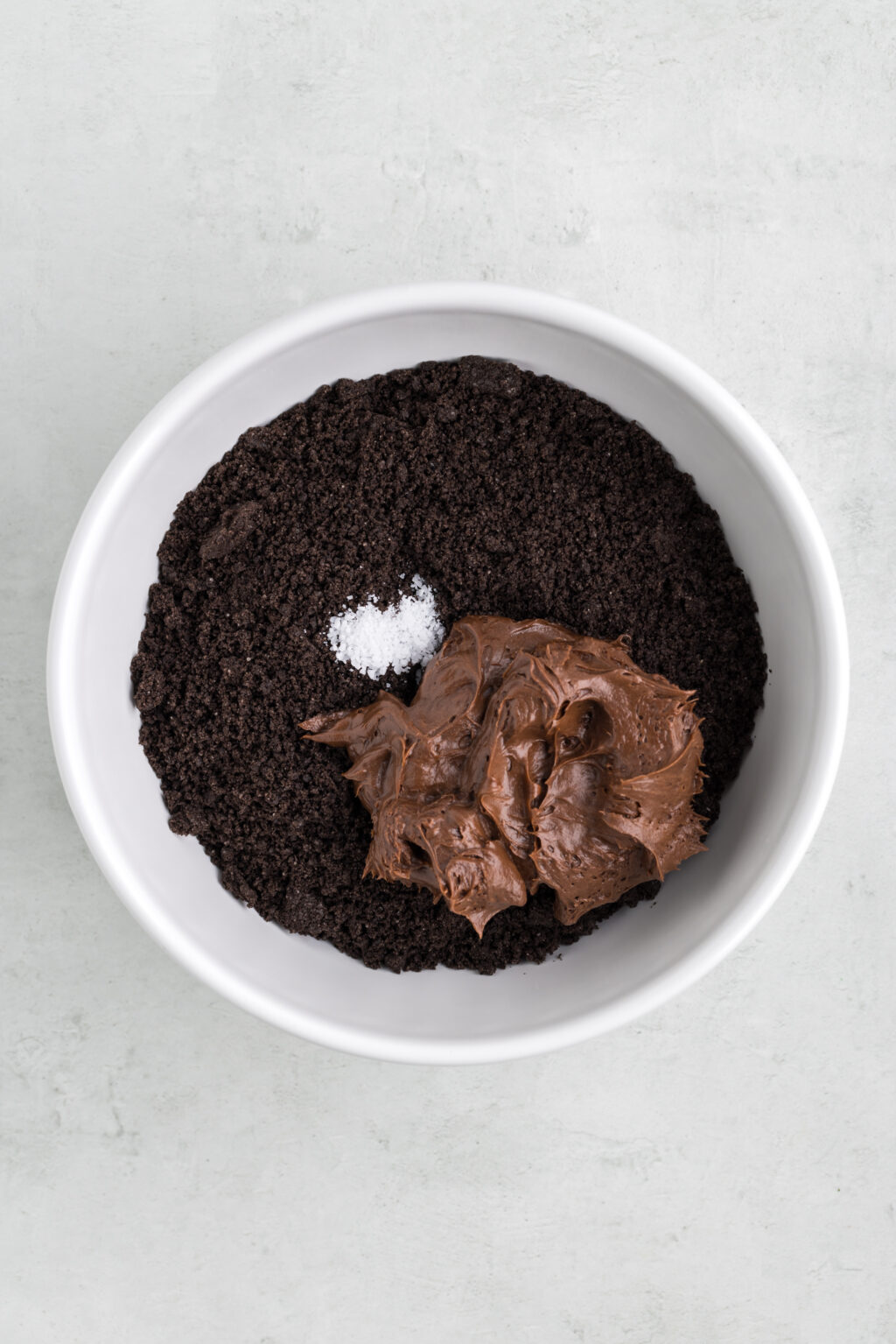 chocolate frosting in bowl with oreo crumbs