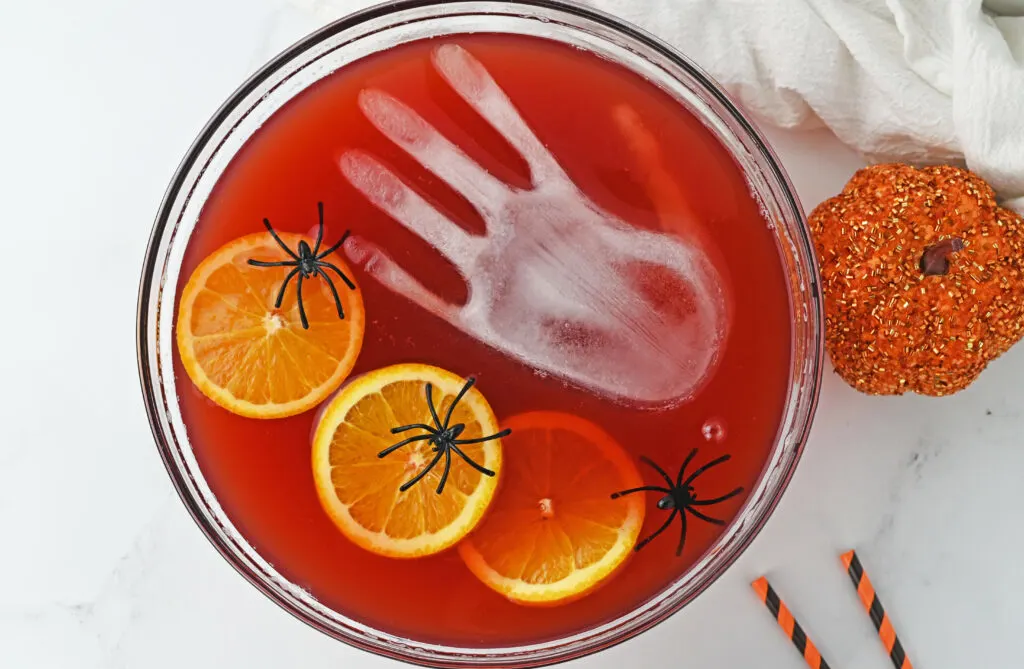 bowl of red spooky halloween punch with frozen ice hand