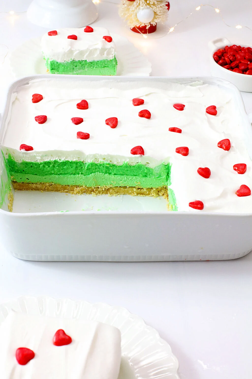 grinch lush dessert in white pan with slice taken out of it