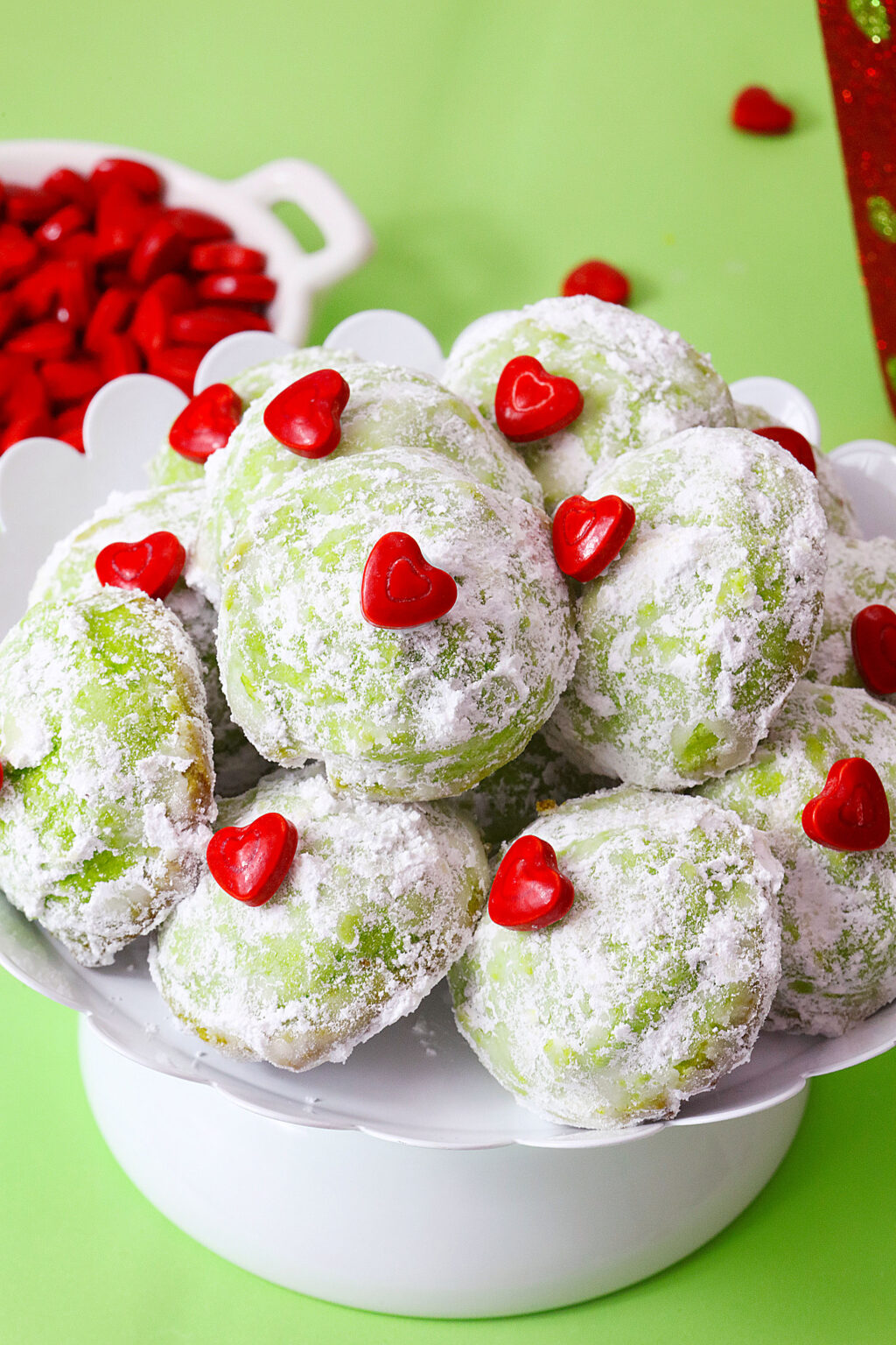 green grinch snowball cookies on white serving tray