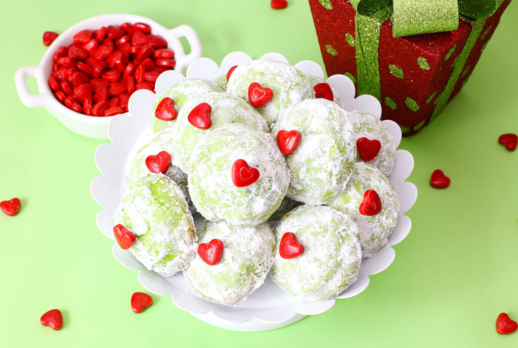 green grinch snowball cookies on a white serving tray