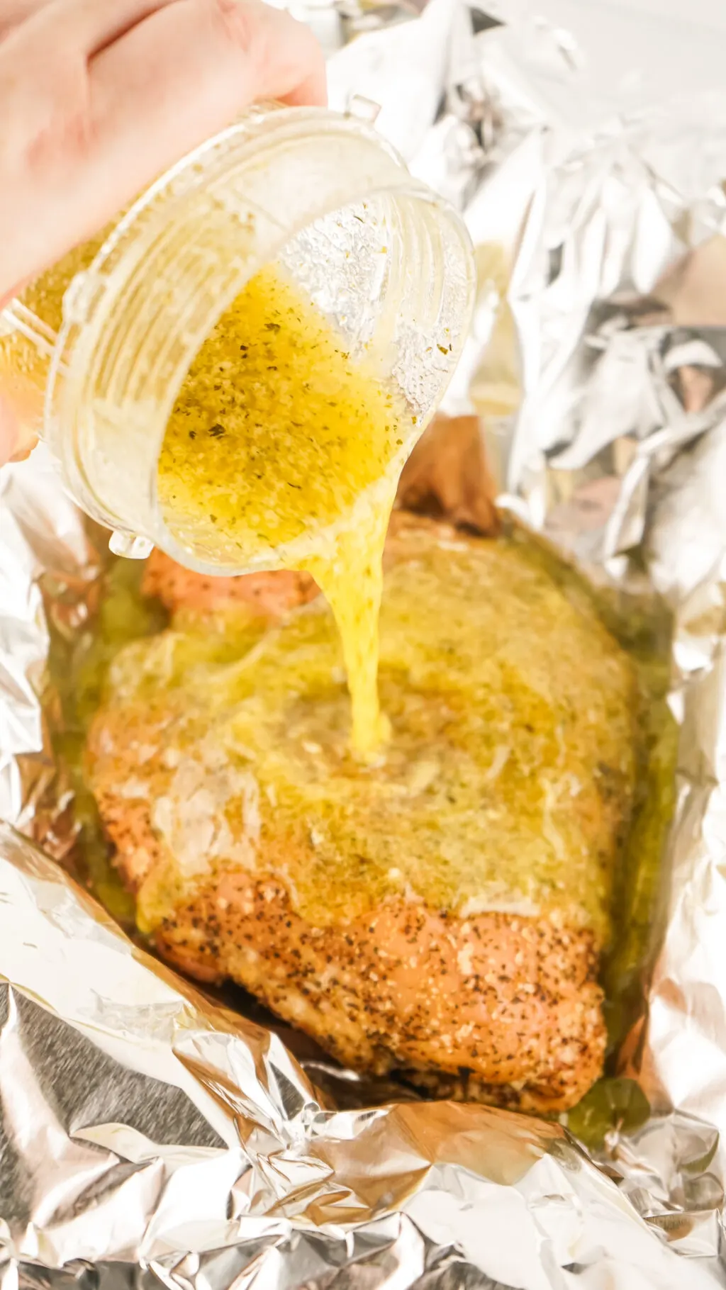 butter being poured into foil packet with smoked turkey breast