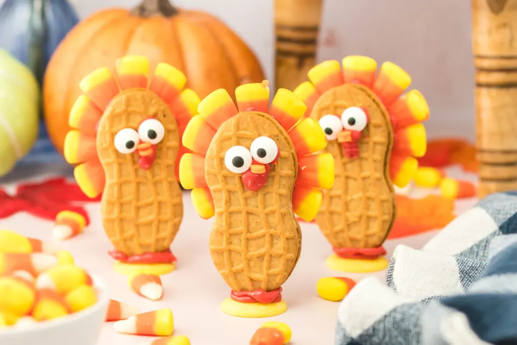 three nutter butter turkey cookies on a thanksgiving dessert table