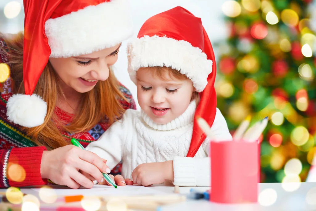 child writing a holiday note to mom