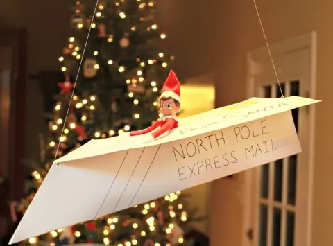 elf in a paper air plane arriving from the north pole