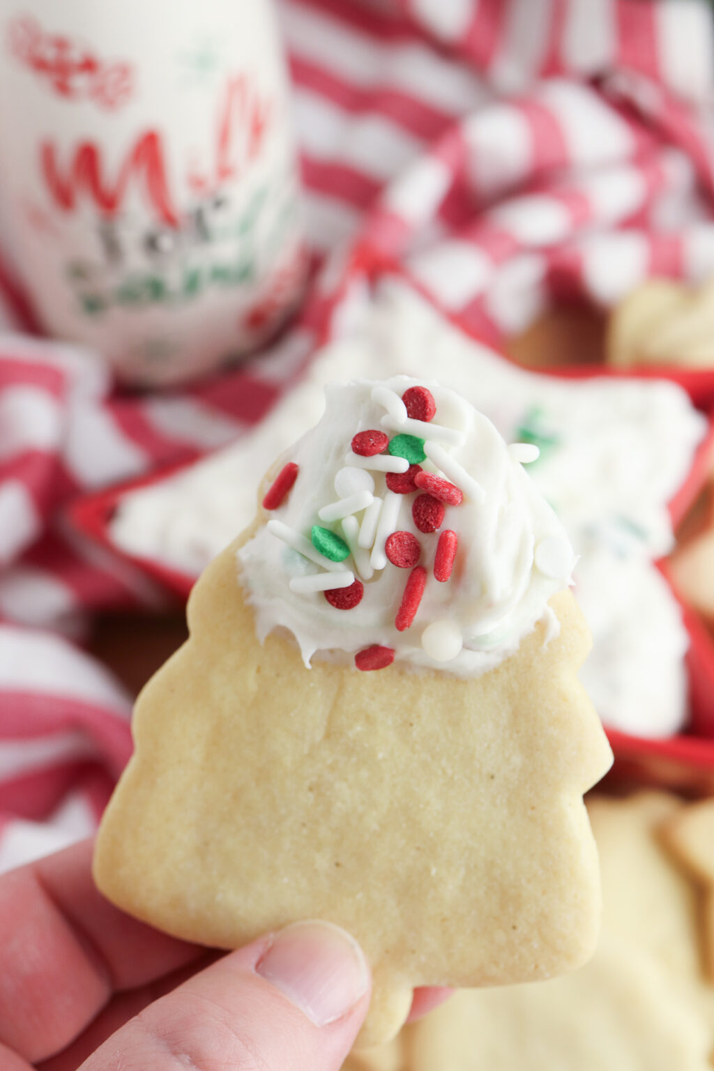 hand holding christmas cookie with sugar cookie dip on it