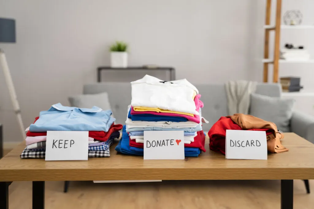 keep donate and discard piles of clothes