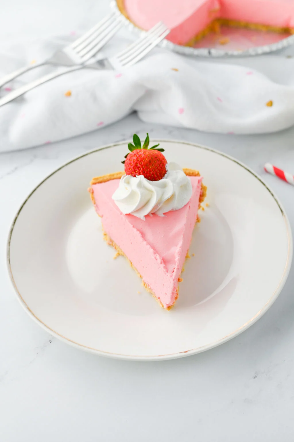 slice of strawberry jello pie with whipped cream and strawberry on top